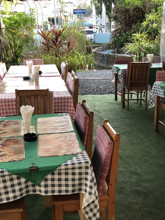Tables with checked cloths in the garden, among plants