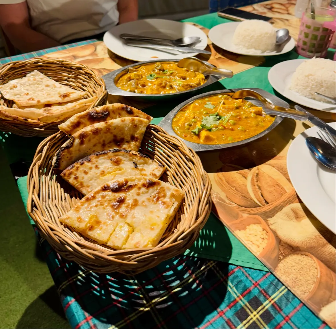 A basket of naan with four curries